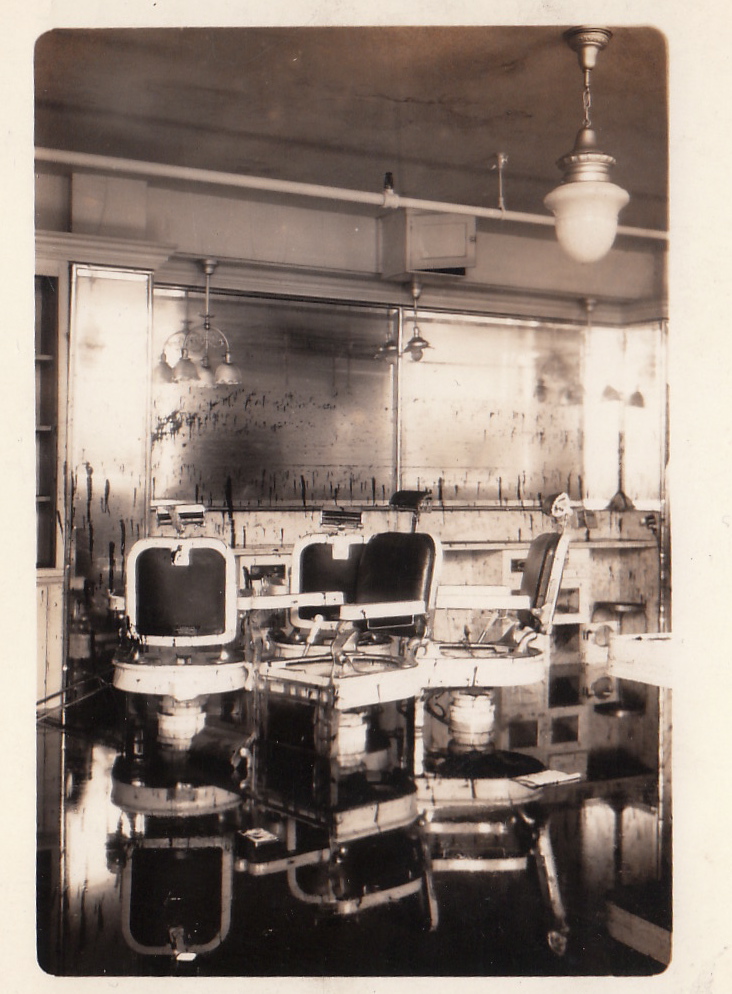 Barber shop of the Grosvenor Building with barber chairs reflected in the remnants of storm surge waters. New England Hurricane of 1938. Rhode Island, Providence