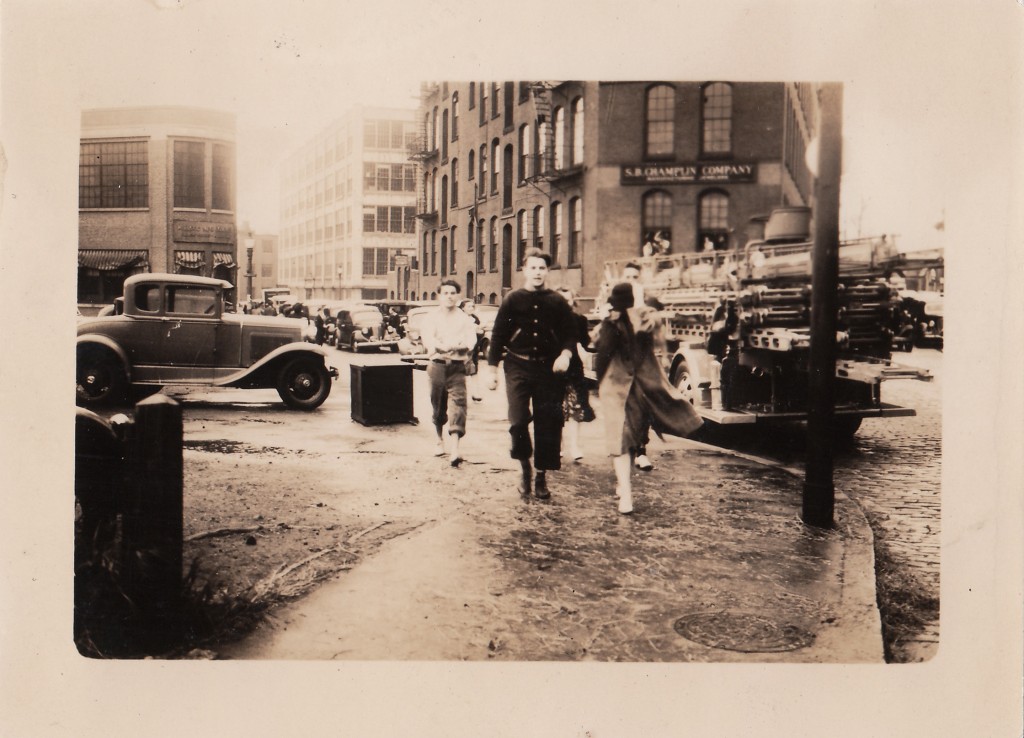 Walking down Ship Street after the waters receded. Men have their trousers rolled up to navigate areas of standing water. New England Hurricane of 1938. Providnece, Rhode Island, September 22, 1938.